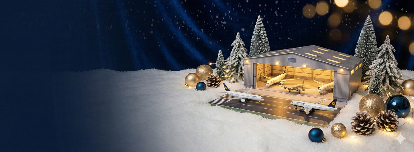 Model of a cabin in a snowy landscape with Christmas decorations under a dark blue sky.